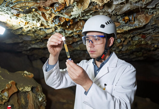 Scientist collecting extremophilic bacteria in deep cave