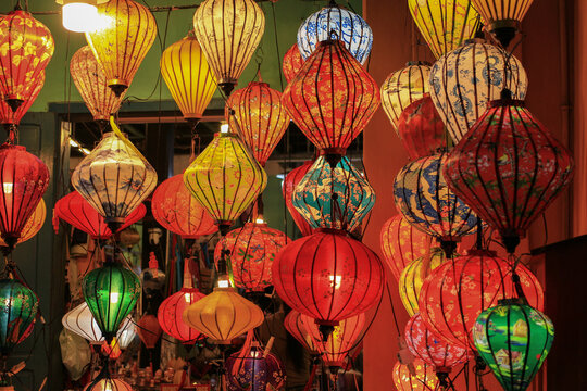 Traditional colorful silk lanterns glowing at night market in Hoi An ancient town, Vietnam.