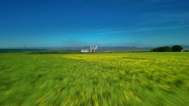 Aerial drone perspective moving across vibrant grassy terrain. Natural outdoor landscape with rich green vegetation, wide open space and relaxing countryside atmosphere viewed from above.