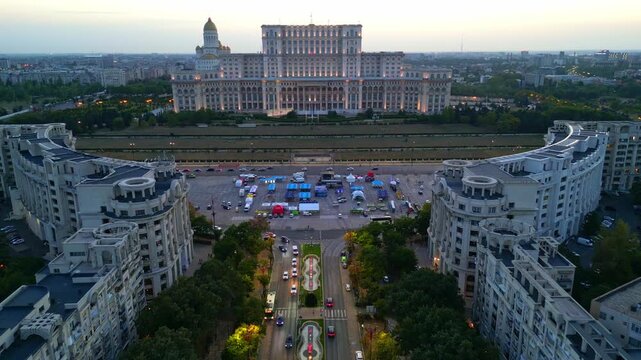 High angle twilight view of the Palace of the Parliament in Bucharest, Romania. Famous heavy building landmark with glowing city lights at sunset.	