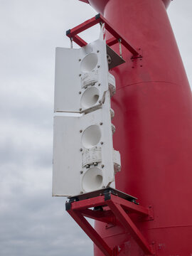 Maritime fog horn nautofon mounted on a red navigation beacon structure