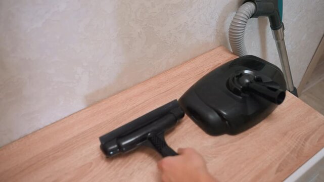 Vacuum nozzles displayed on wood counter, closeup product comparison showing heads and connectors, inspection of brush and squeegee attachments, ergonomic design and plastic finish, practical