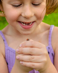 A ladybug on a child hand. Selective focus. © yanadjan