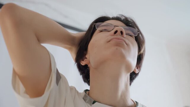 Young man feels satisfied afterward. Individual expresses contentment after completing tasks. Young adult shows obvious pleasure and relaxation after finishing household chores successfully