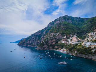 Fototapeta premium Aerial view of Fornillo Beach and the Amalfi coast near Positano, Italy. Drone panorama of breathtaking cliffside townscape with colorful houses