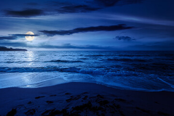 Fototapeta premium black sea landscape in summer at night. full moon over bulgaria nature landscape with sandy beach. mysterious summer vacation at the sea shore concept. waves and empty beach. remote vacation scene