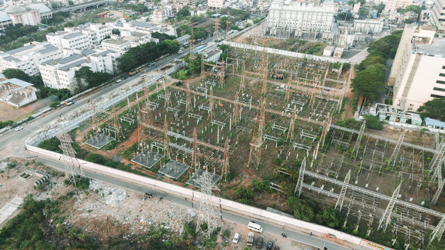 Aerial view of urban electrical substation surrounded by residential apartment buildings and city infrastructure showing power grid integration with dense neighborhood