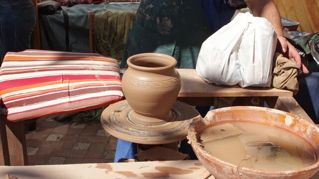 Handmade ceramic vase spinning on a potter's wheel at an artisan market. Perfect for arts, crafts, and heritage concepts.