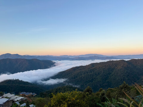 The mountain village overlooking a dense fog layer valley under a clear morning sky