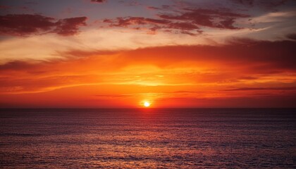 Obraz premium Dramatic Red Orange And Yellow Sunset Over The Ocean Evokes Peace And Tranquility For A Summer Vacation