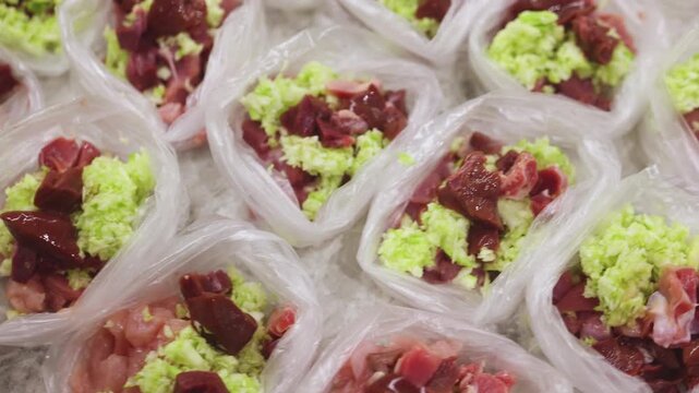 Preparing bowls with Bones And Raw Food diet dog food at home, preparation of natural raw BARF for cats and pets, with ingredients, duck, turkey, offals and vegetables, portions in containers bags 
