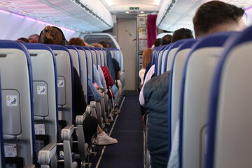 Passengers seated inside commercial airplane cabin during flight © Tamasito
