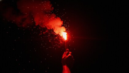 A close-up of a hand holding a glowing red emergency signal flare against a pitch-black background with smoke and sparks flying into the night. © dang