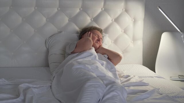 An elderly woman's restless sleep in her bed at home