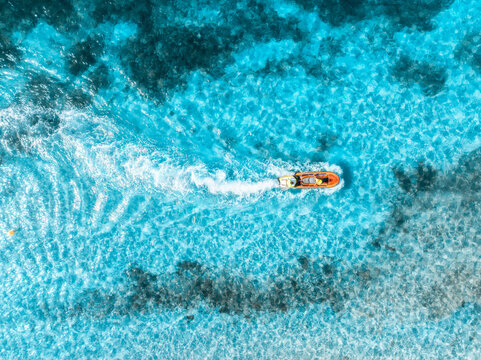 Aerial drone view of beautiful floating boat in blue sea on sunny day. Summer vacation. Mallorca island, Spain. Top down view of boat, sea, turquoise water. Travel. Tropical seascape. Yachting. Cruise