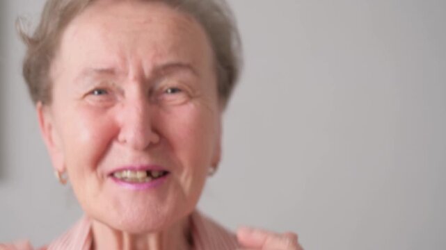 A close-up of the face of a contented, smiling, dancing old woman