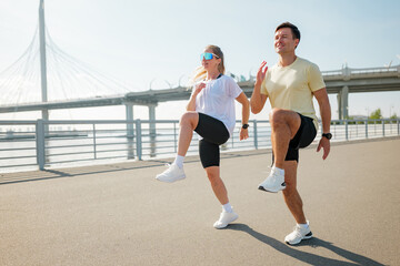 Fototapeta premium Energetic morning joggers enjoy a sunny day at the waterfront with a stunning bridge in the background