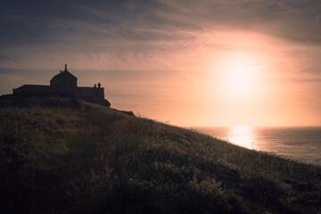 Obraz premium Sunset on the Cornish coat at the Chapel of St Nicholas, St Ives.