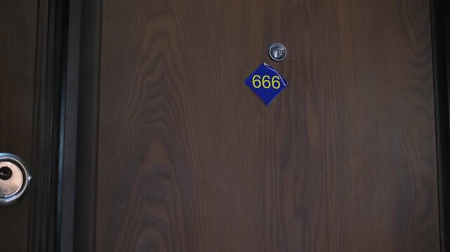 A closing door with the number "666" in a hotel or apartment