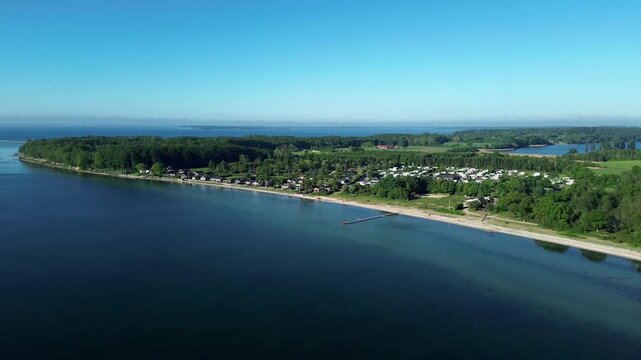 Aerial view of   Campsite on a beautiful coast, scenic beach, and green landscape by the sea in Denmark, Europe