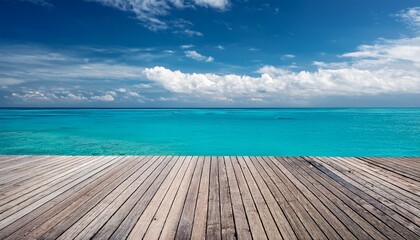 Fototapeta premium Wooden Deck Overlooks A Bright Turquoise Ocean Under A Blue Sky With Fluffy Clouds
