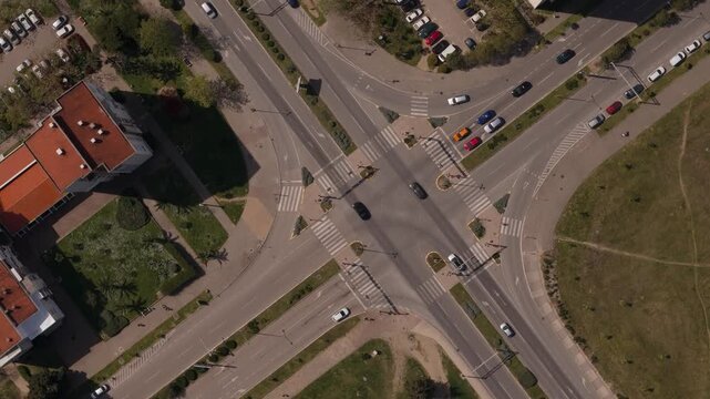 Kruzni tok intersection seen from drone with visible traffic flow, marked pedestrian crossings, landscaped medians and adjacent apartment blocks in Montenegrin urban area capturing top-down view of ro