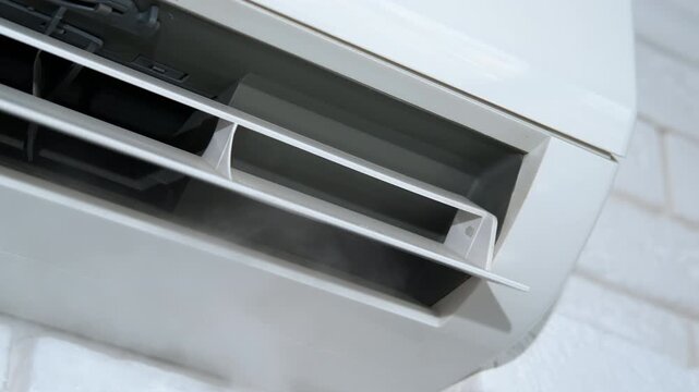 Fresh conditioning in room attached on wall. A view of modern white cooling system working on the wall in the flat
