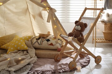 Cute wigwam with fairy lights and toys in stylish child's room © New Africa