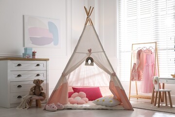 Cute wigwam, clothes, cushions and toy in stylish child's room © New Africa