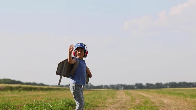 A happy child runs around the field with a toy jetpack