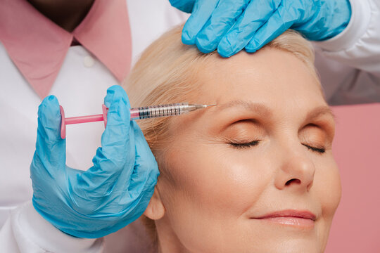Senior woman receiving botox treatment on forehead for wrinkle reduction