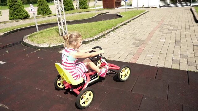 Beautiful little girl rides mechanical go-kart