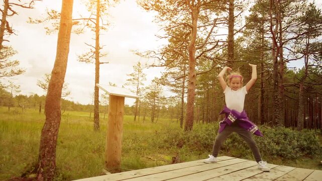 Little beautiful girl walks on swamp in Estonia
