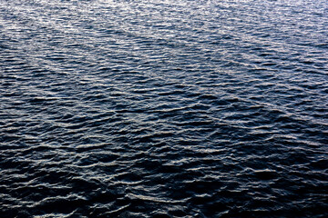 Obraz premium Deep blue ocean texture with cold evening light. Rhythmic sea waves pattern.