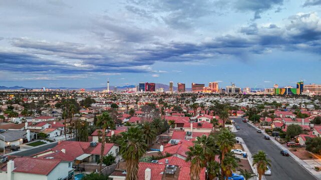 Aerial drone view flying forward over a Las Vegas suburban neighborhood at dusk with the Strip skyline in the background