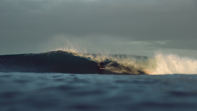 surfer large tubular wave sunrise atlantic ocean