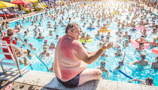 Crowds gather at public pool during extreme heat on a sunny day with people enjoying the water and sun