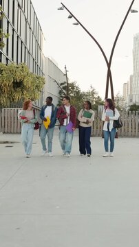 Diverse group of university students walking together on campus