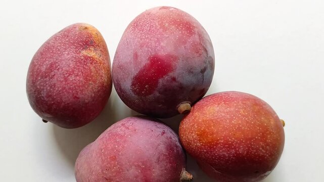 Four ripe red mango Mangifera indica fruits isolated on white background