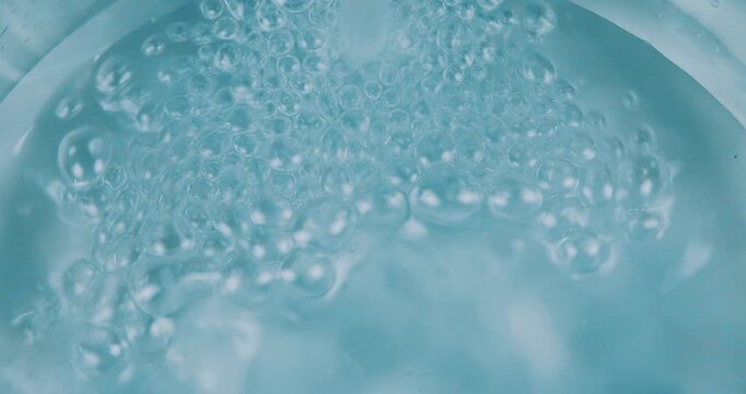 Acqua che scorre in un contenitore di vetro formando bolle d'aria