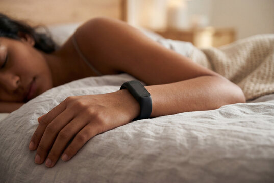 Woman sleeping wearing minimalist black smartwatch in cozy bed