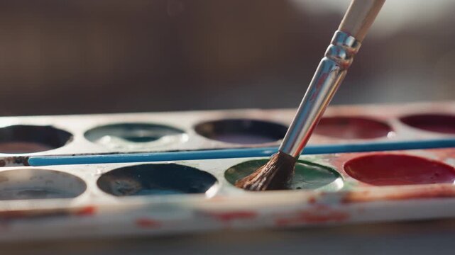 Artist blends colors. Child artist mixing vibrant paint. Student artist carefully mixes pigments on colorful palette. Vivid image of learner artist skillfully combining shades on paint palette