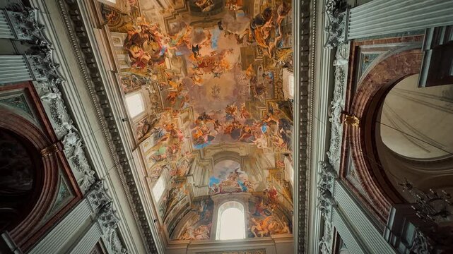 A breathtaking interior view of Sant Andrea della Valle in Rome, showcasing magnificent golden ornaments, high marble columns, and exquisite Baroque frescoes painted on the grand church ceiling.

