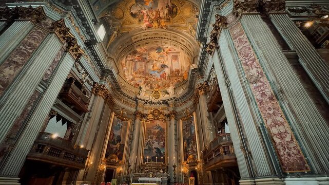 A breathtaking interior view of Sant Andrea della Valle in Rome, showcasing magnificent golden ornaments, high marble columns, and exquisite Baroque frescoes painted on the grand church ceiling.

