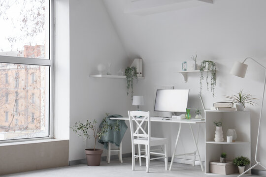 Interior of light office with programmer's desk and plants