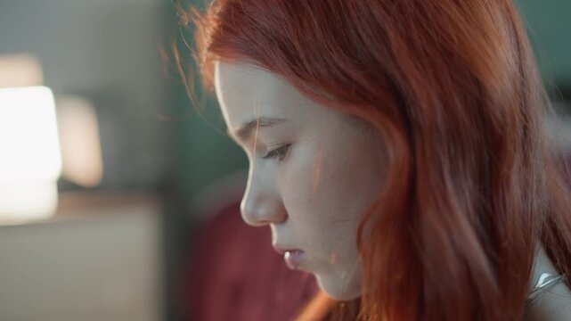 Peaceful auburnhaired woman foresees rain. Freckled woman with auburn hair expects impending thunderstorm. Serene redheaded woman anticipates arrival of significant weather disturbance