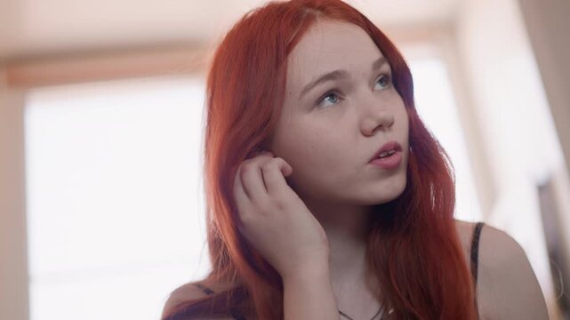 White redhaired young woman by window whispering foresight, closeup expressions, soft natural light, serene mood, jewelry, talisman testing, intimate portrait, contemplative gaze