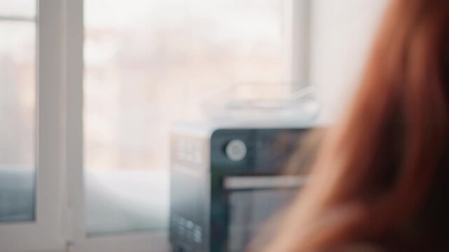 Redhead white woman reading letter by desk, furrowed brow and focused expression, envelope and paperwork spread near window, urban apartment backdrop, concerned mood, document review scene