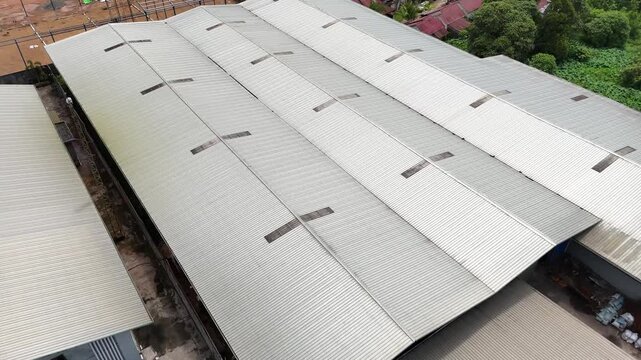 A view from the roof of a large industrial warehouse and the metal roof of a manufacturing facility.