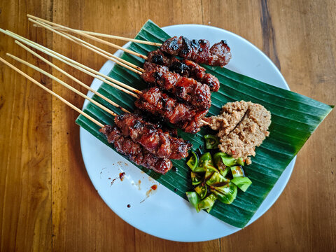 Sate Maranggi Indonesian Grilled Meat Skewers on Banana Leaf with Oncom and Green Chili, Traditional Sundanese West Java Food